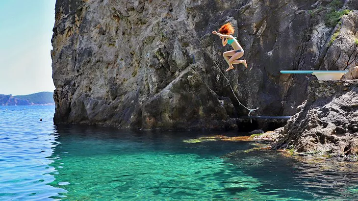 Saltando desde el trampolín en la playa de La Grotta