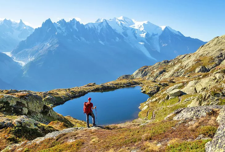 Senderista contemplando el lago de Cheserys en el famoso Tour del Mont Blanc