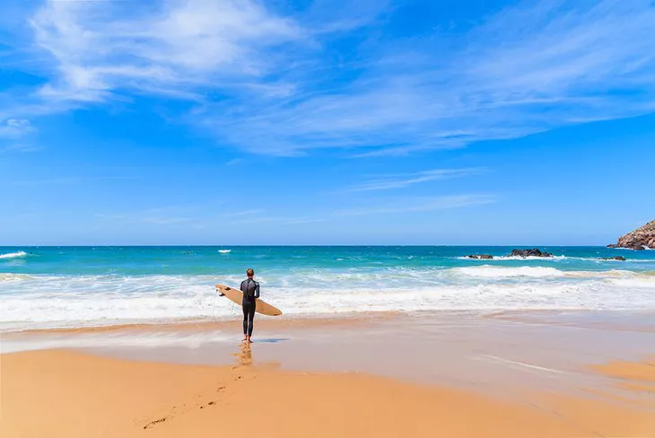 Surfista comprobando las olas en la Playa do Amado